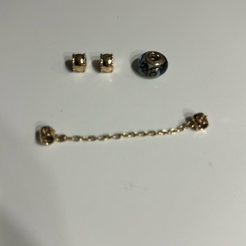 Pandora 2 clips the safety chain and the charm has glass and blue design Gold